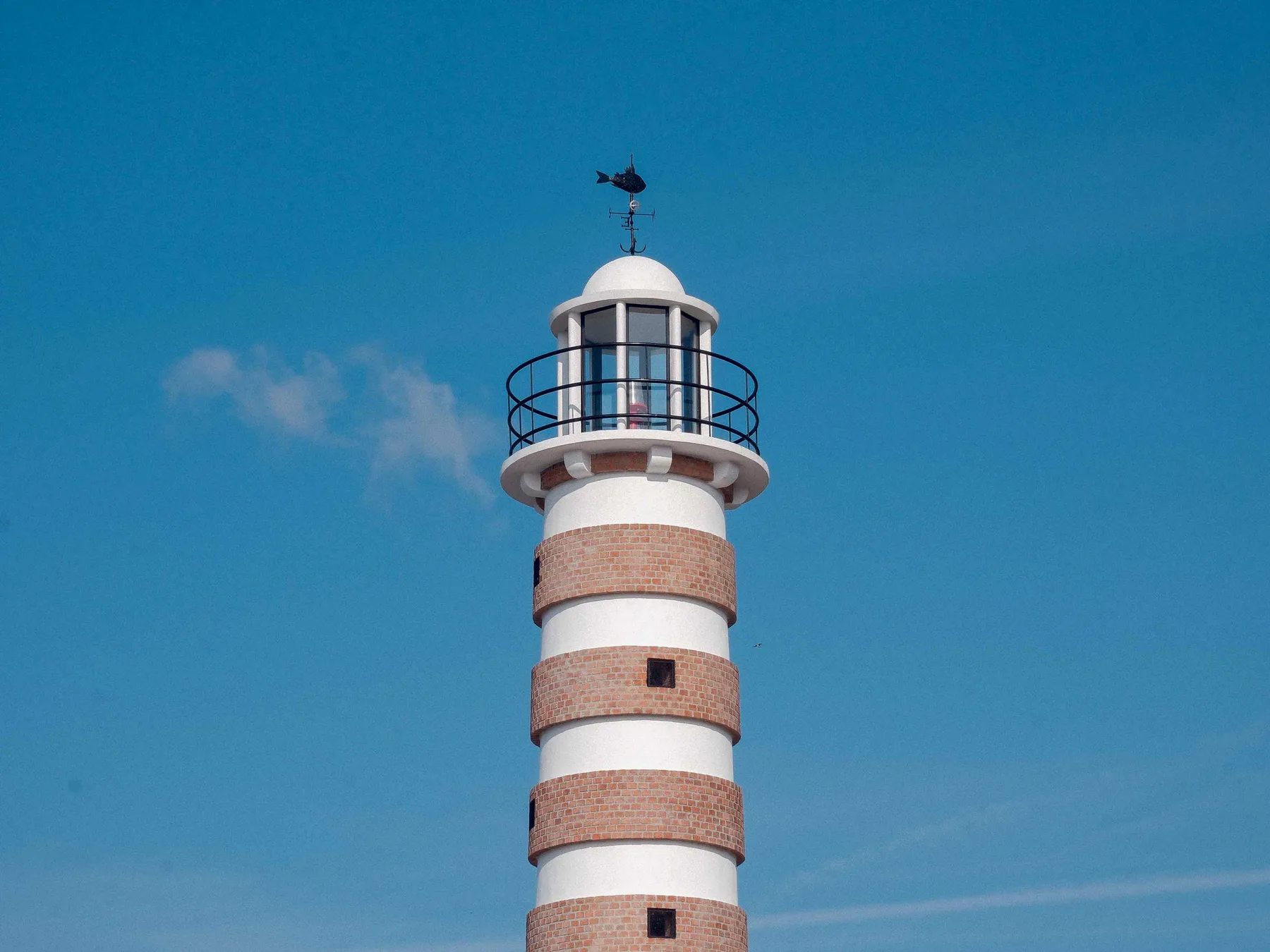 Striped lighthouse against the sky